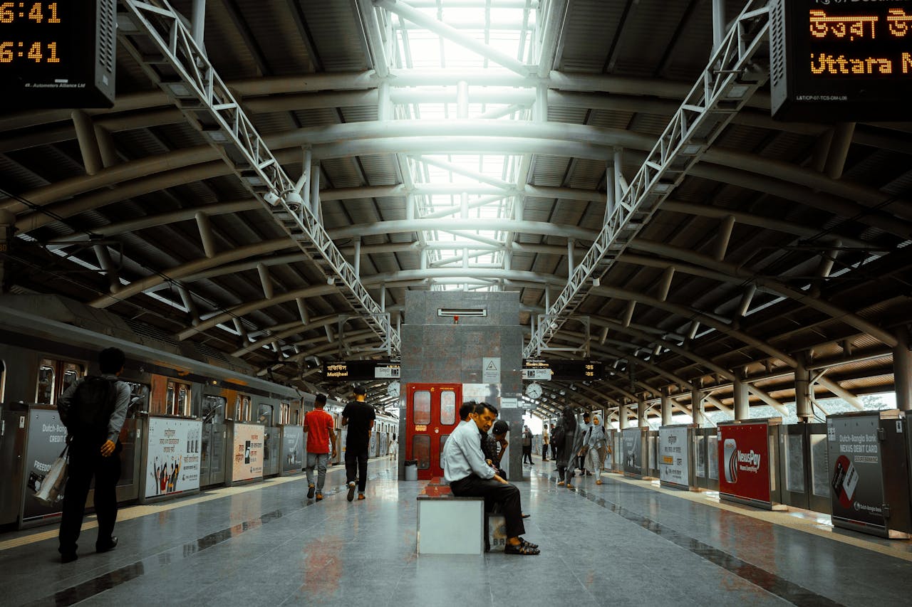 Interior view of a bustling metro station with commuters in transit, modern architecture.